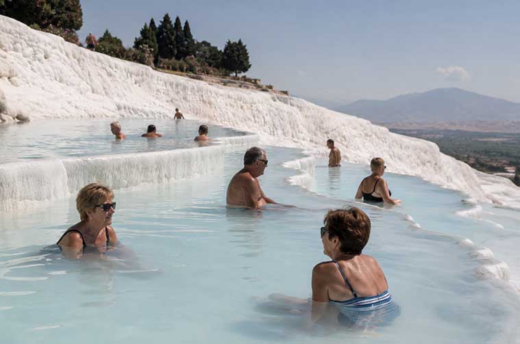 Viajeros disfrutando de las piscinas naturales de Pamukkale